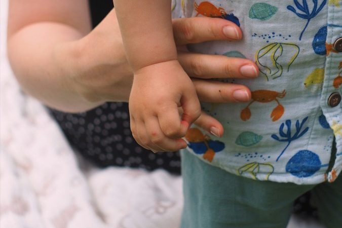 La manina di un bambino appoggiata alla mano della mamma